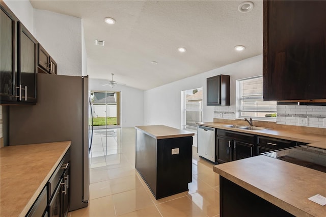 4954 SW 40th Pl, Ocala, FL 34474 - kitchen with a sink, stainless steel appliances, decorative backsplash, a kitchen island, and vaulted ceiling