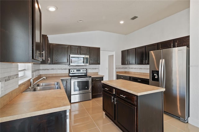 4954 SW 40th Pl, Ocala, FL 34474 - kitchen featuring stainless steel appliances, a sink, a kitchen island, lofted ceiling, and light tile patterned flooring