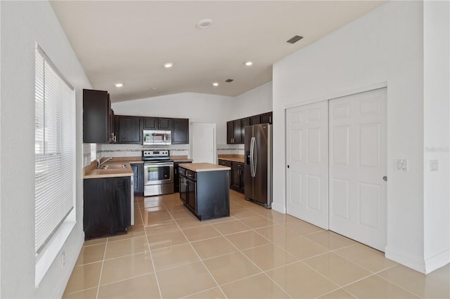 4954 SW 40th Pl, Ocala, FL 34474 - kitchen with stainless steel appliances, a sink, lofted ceiling, light countertops, and a kitchen island