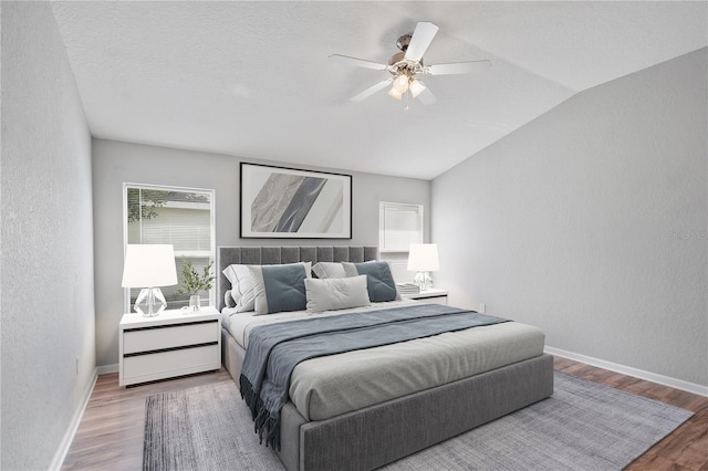 4954 SW 40th Pl, Ocala, FL 34474 - bedroom featuring vaulted ceiling, wood finished floors, a textured wall, baseboards, and a ceiling fan