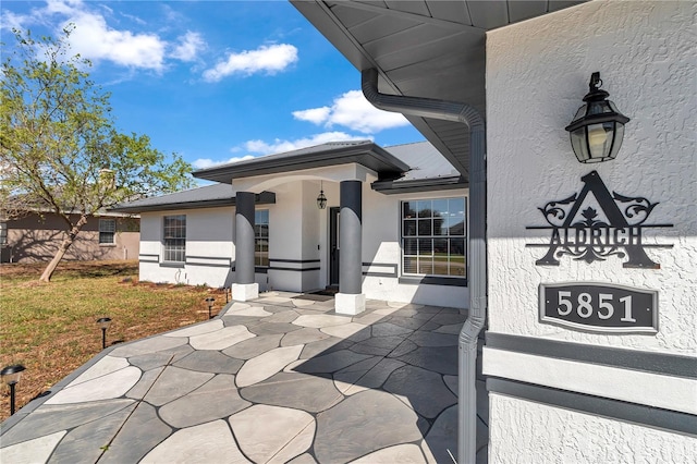 exterior space featuring a yard, metal roof, a patio, and stucco siding