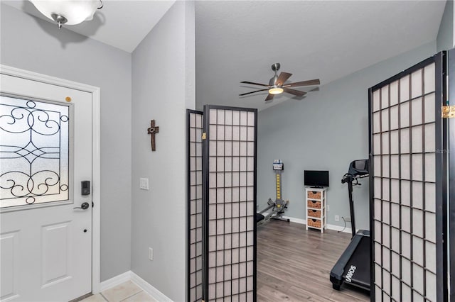 entryway with ceiling fan, baseboards, and wood finished floors