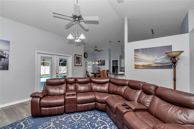 living area with baseboards, ceiling fan with notable chandelier, wood finished floors, and french doors