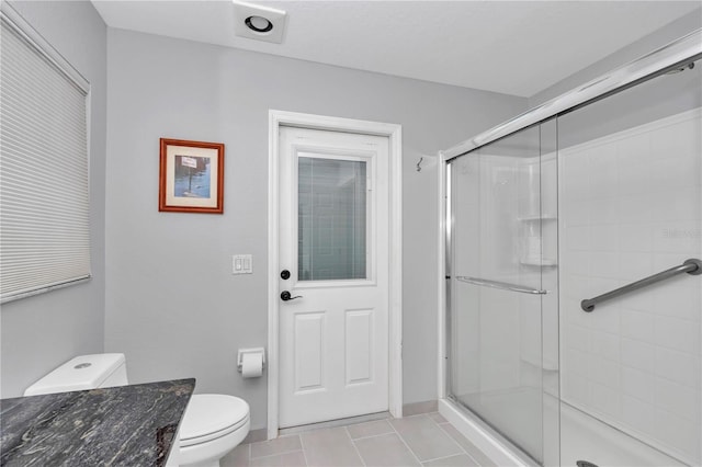 full bath featuring a shower stall, toilet, and tile patterned floors