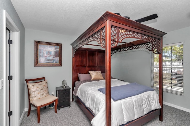 carpeted bedroom featuring a textured ceiling and baseboards