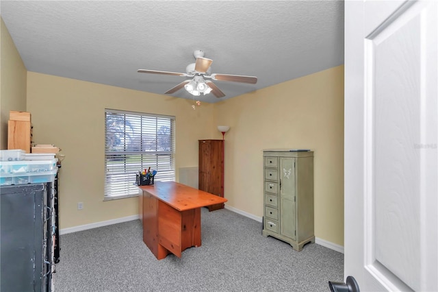 home office with light carpet, ceiling fan, a textured ceiling, and baseboards