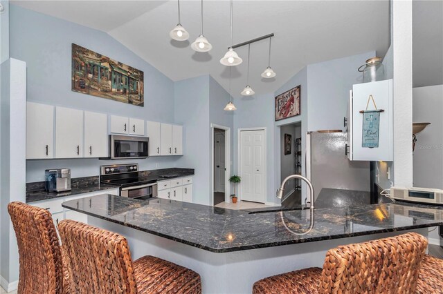 kitchen with high vaulted ceiling, stainless steel appliances, a peninsula, a sink, and white cabinetry