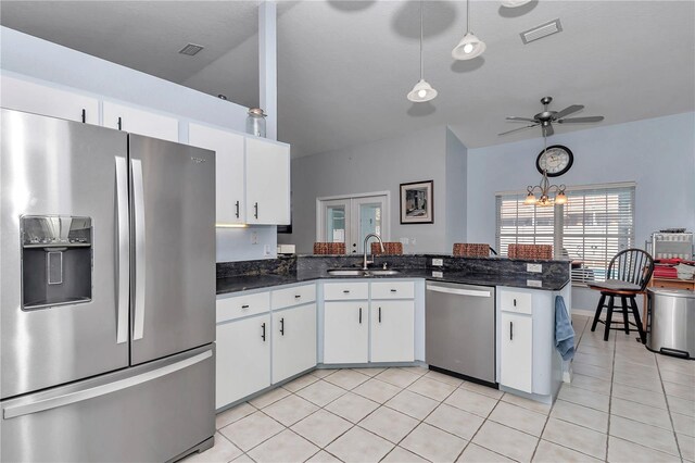 kitchen with light tile patterned floors, stainless steel appliances, a peninsula, a sink, and visible vents