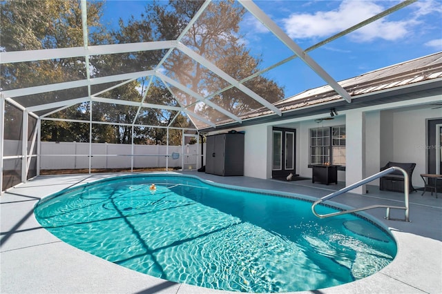 view of swimming pool with ceiling fan, a fenced backyard, a lanai, a fenced in pool, and a patio area