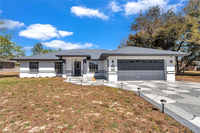 view of front of home with a garage, metal roof, and stucco siding