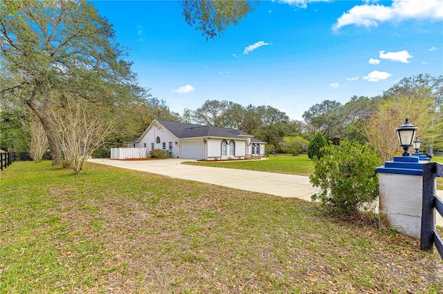 exterior space featuring driveway, an attached garage, and fence