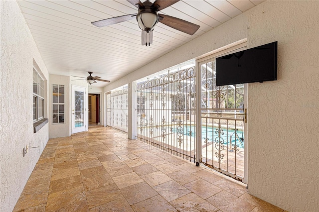 unfurnished sunroom with a ceiling fan