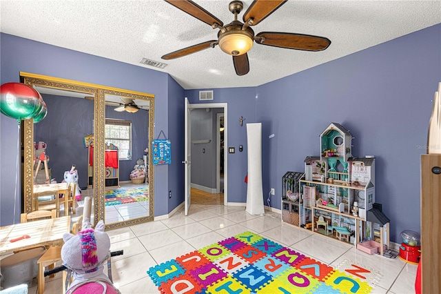 rec room featuring visible vents, a textured ceiling, baseboards, and tile patterned floors