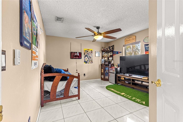 tiled bedroom with a ceiling fan, visible vents, and a textured ceiling