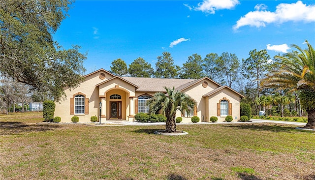 mediterranean / spanish-style house featuring a front lawn and stucco siding