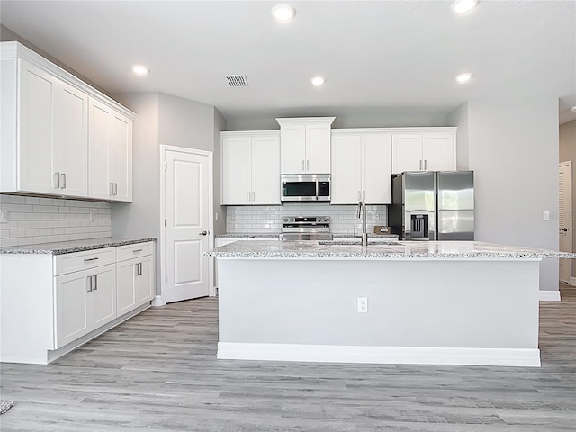 kitchen featuring white cabinets, light wood-style floors, visible vents, and stainless steel appliances