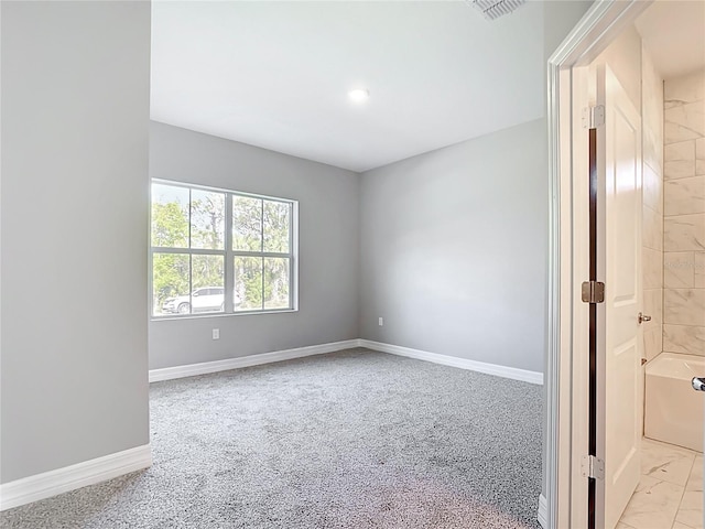 empty room featuring baseboards, light carpet, and visible vents