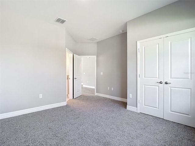 unfurnished bedroom featuring visible vents, baseboards, carpet, and a closet