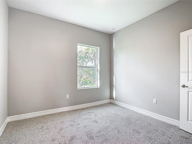 unfurnished room featuring baseboards and carpet