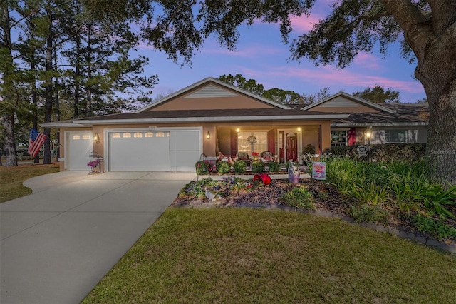 ranch-style house with a garage, driveway, a yard, and stucco siding