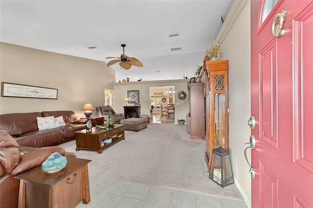 living area featuring a ceiling fan, light carpet, visible vents, and light tile patterned flooring