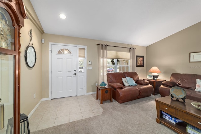 living room featuring lofted ceiling, light colored carpet, baseboards, and light tile patterned flooring