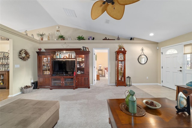 living room featuring ceiling fan, visible vents, vaulted ceiling, and light colored carpet