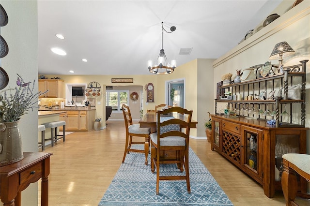 dining room with light wood-type flooring, visible vents, recessed lighting, and an inviting chandelier