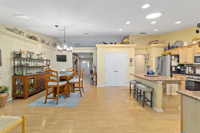 dining area with light wood-style flooring, a chandelier, and recessed lighting