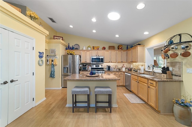 kitchen with light wood-style floors, appliances with stainless steel finishes, a sink, and light brown cabinetry