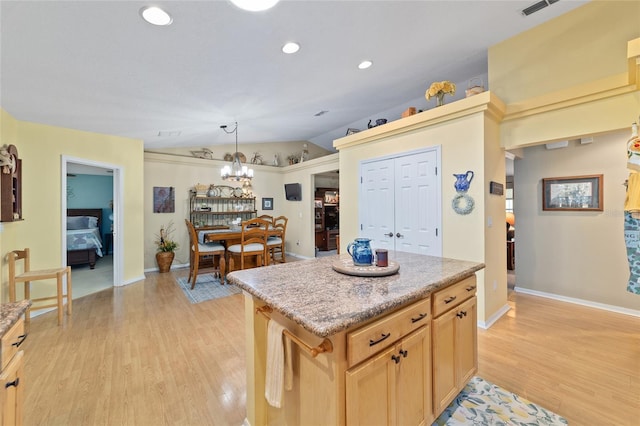 kitchen with a center island, vaulted ceiling, light wood-style floors, pendant lighting, and recessed lighting