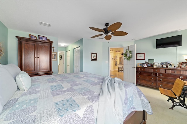 bedroom featuring a ceiling fan, light colored carpet, and visible vents