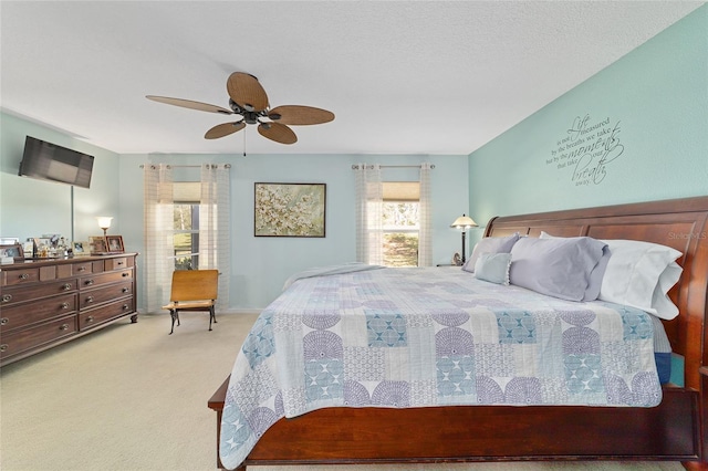 bedroom featuring a ceiling fan, carpet flooring, and a textured ceiling