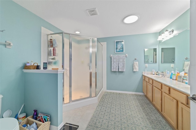 full bathroom with a stall shower, baseboards, visible vents, toilet, and vanity