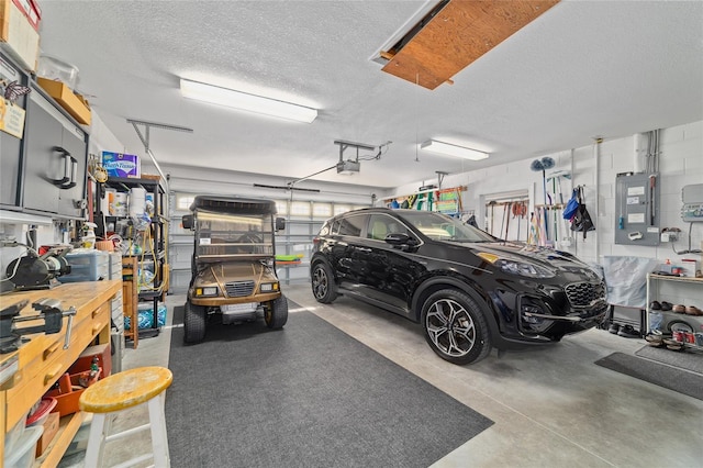 garage with concrete block wall, electric panel, and a garage door opener