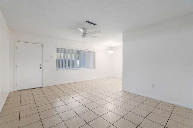 unfurnished room featuring baseboards, a textured ceiling, visible vents, and a ceiling fan