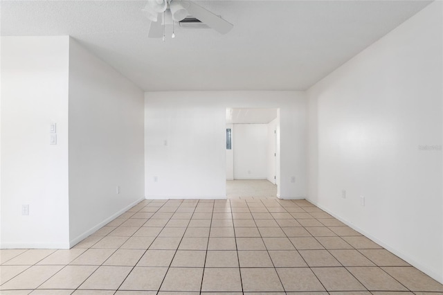 spare room with ceiling fan and light tile patterned floors