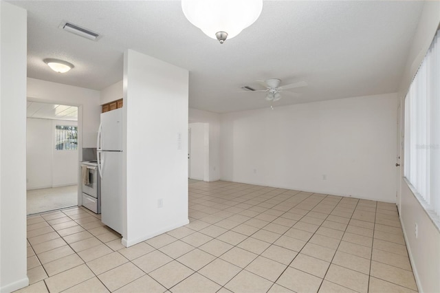 spare room with light tile patterned floors, ceiling fan, a textured ceiling, and visible vents