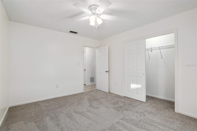 unfurnished bedroom featuring carpet, a closet, visible vents, a ceiling fan, and baseboards