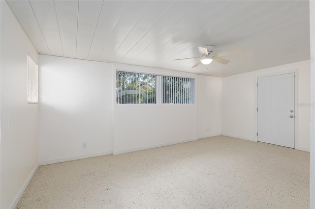 spare room featuring ceiling fan and baseboards