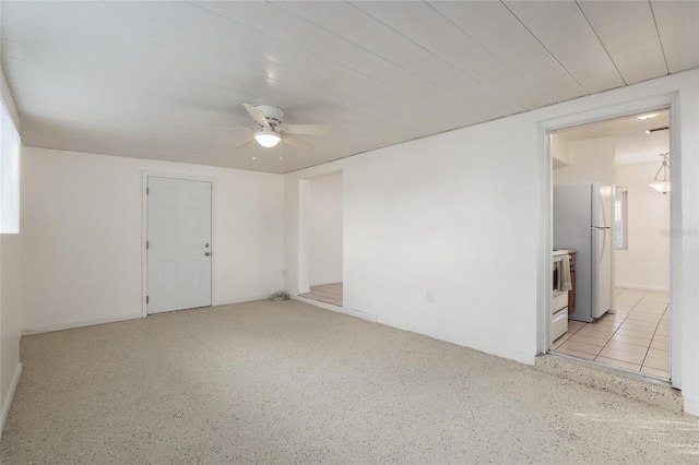 unfurnished room with light speckled floor and a ceiling fan