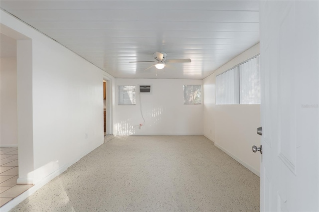 unfurnished room with speckled floor, a wealth of natural light, and a ceiling fan