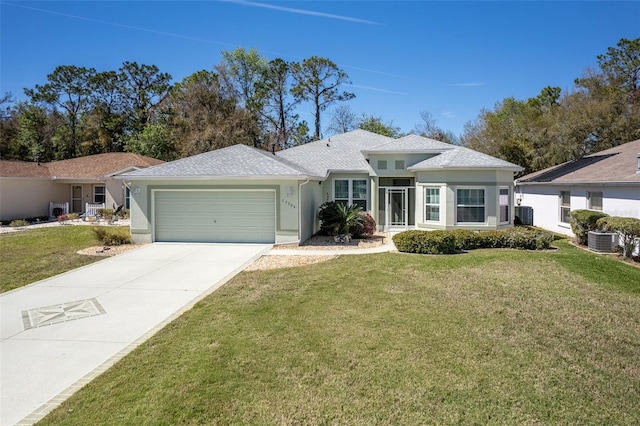 ranch-style home featuring stucco siding, central AC unit, a garage, driveway, and a front lawn