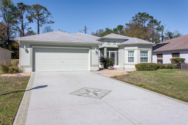 view of front of house featuring a garage, a shingled roof, concrete driveway, stucco siding, and a front lawn