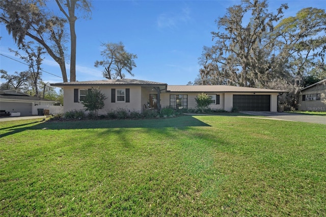 single story home with stucco siding, an attached garage, central AC unit, driveway, and a front lawn