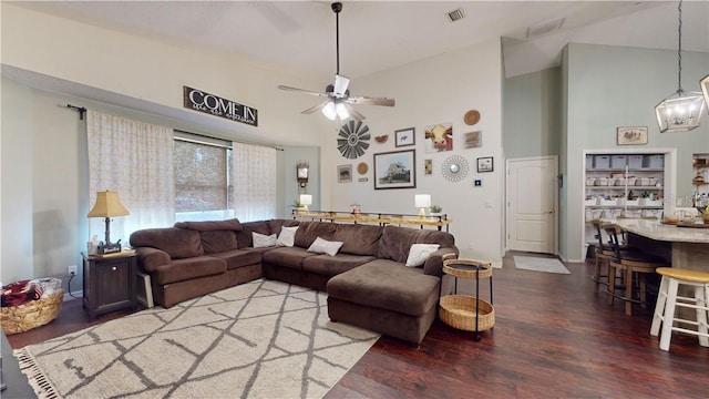 living area with high vaulted ceiling, wood finished floors, visible vents, and a ceiling fan