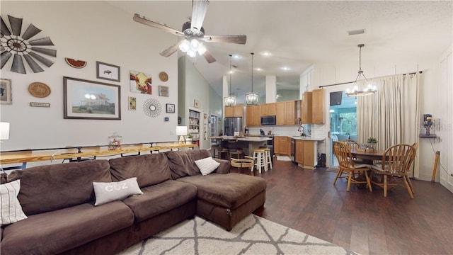 living room featuring high vaulted ceiling, visible vents, dark wood finished floors, and ceiling fan with notable chandelier