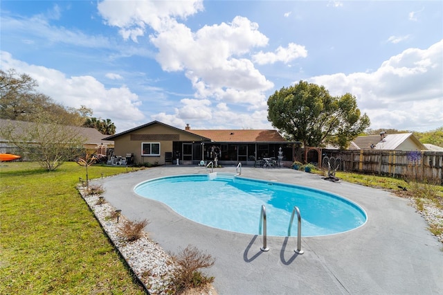 view of pool with fence, a sunroom, a lawn, a fenced in pool, and a patio area