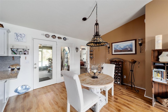 dining area featuring lofted ceiling and light wood-style flooring