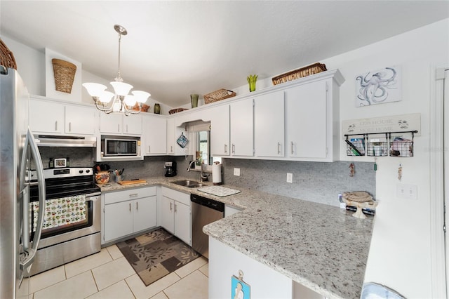 kitchen featuring under cabinet range hood, a peninsula, a sink, appliances with stainless steel finishes, and backsplash